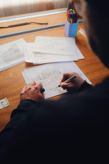 Architect reviewing construction plans on a desk.