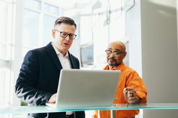 Two men at work looking at a laptop and discussing the job at hand