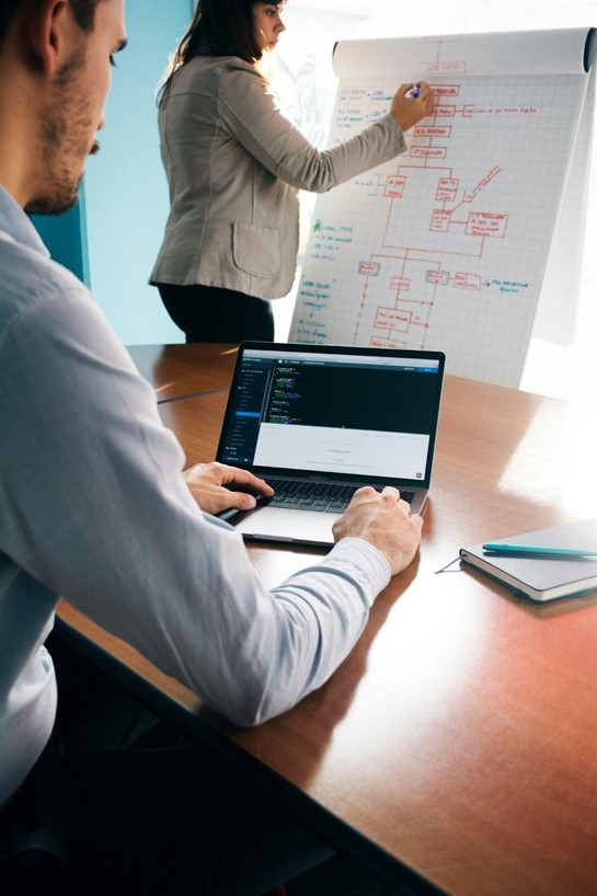 woman on white board and man at computer