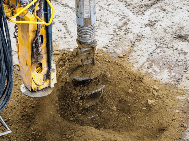 Drilling machinery excavating soil for underground utilities