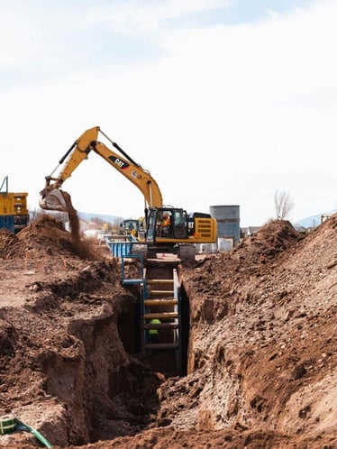 Excavator digging deep trenches for a heavy civil construction project