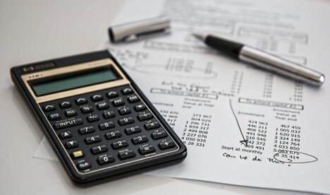 calculator on financial documents with notes for cost control