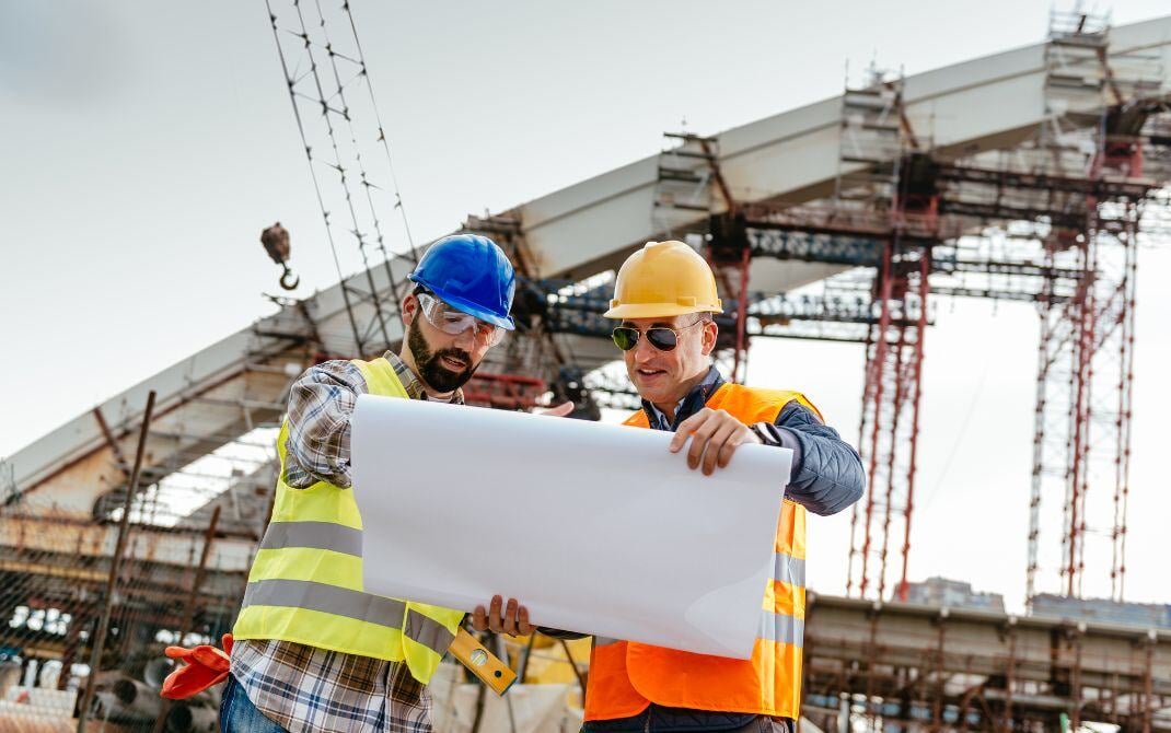 contractors on site looking at roll of paper