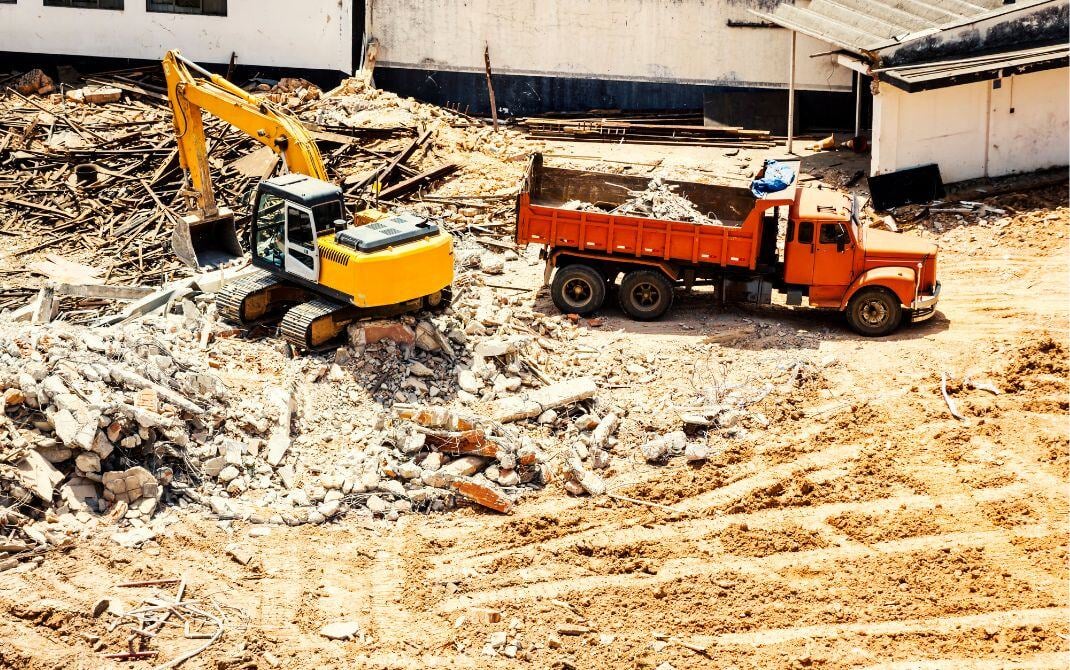 Demo site with truck hauling and heavy equipment