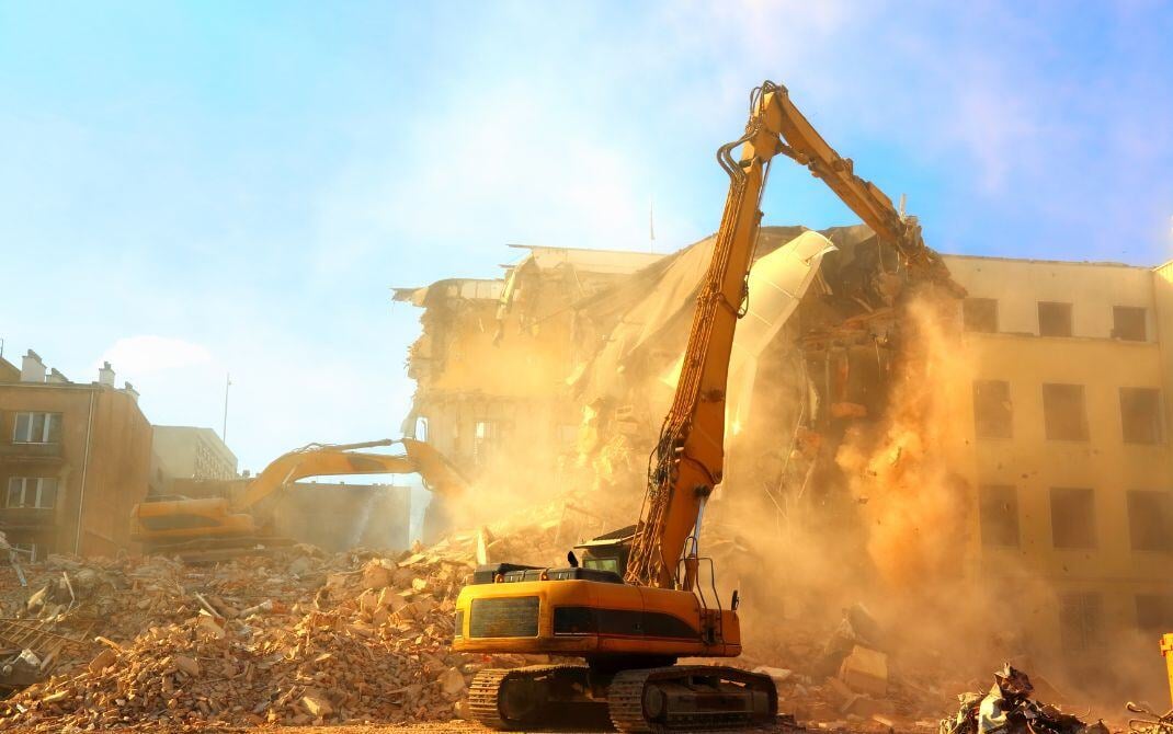 excavators demoing a building