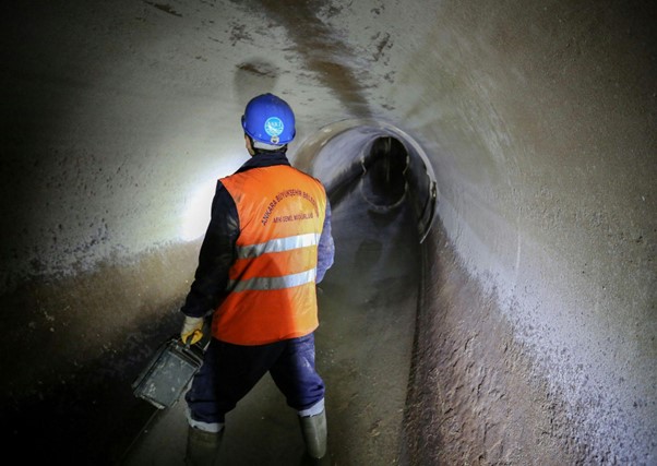 worker inspecting tunnel for underground utility