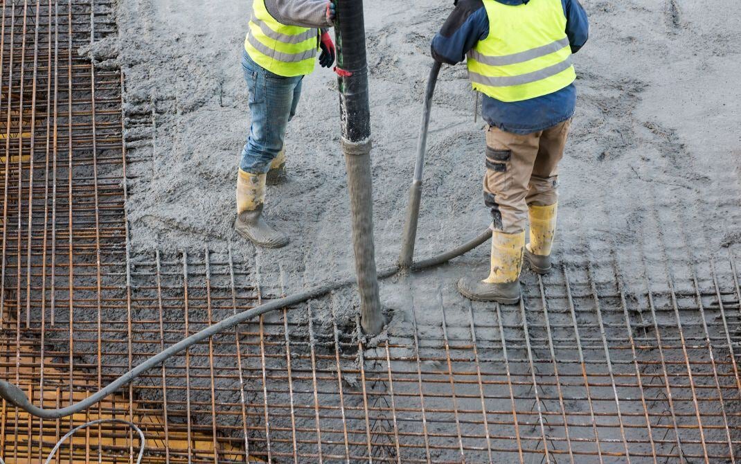 workers pouring concrete over base